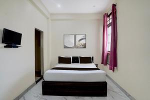 a bedroom with a bed and a tv in it at Hotel O Krishna Villa in Gomti Nagar +21 photos