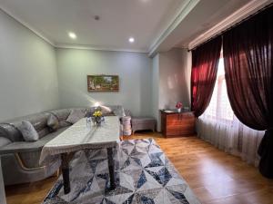 a living room with a couch and a table at Shuxrat hotel in Chilanzar