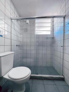 a bathroom with a toilet and a glass shower at Dom Pedro Hotel in Petrópolis +58 photos