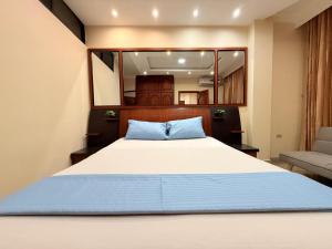 マチャラにあるSuite exclusiva en Machalaの大きなベッドと椅子のある寝室