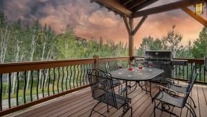 a patio with a table and chairs on a deck at Brown Bear Chalet in Steamboat Springs