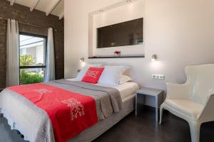 a bedroom with a bed with a red blanket and a window at Villa Azur in Saint-François +13 photos