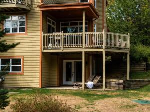 a house with a deck and a porch at L'Aiglon - Nature Golf and Relaxation in Mont-Tremblant in Mont-Tremblant