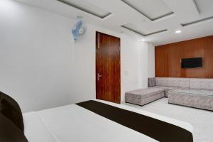 a hotel room with a bed and a couch at Hotel O Dada Hotel& Restaurant in Sūrajpur