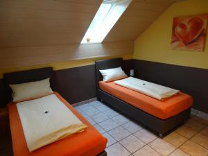 two beds in a small room with a skylight at Pension Wolkenstein in Langenbruck