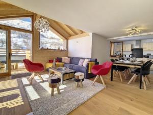un soggiorno con un divano blu e sedie rosse di Chalet moderne avec sauna près des pistes - FR-1-344-1160 a Praranger Altre 10 foto