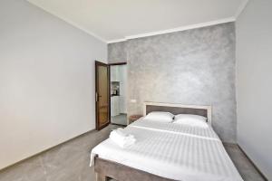 Un dormitorio con una cama blanca y un espejo. en Skyway hotel, en Ereván