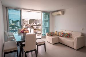 ein Wohnzimmer mit Sofa und Tisch in der Unterkunft Rodadero Gaira - Apto con piscina a 2 cuadras de la playa in Rodadero