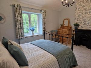 a bedroom with a bed and a window at Riverside Cottage in Aycliffe