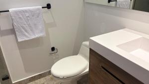 a bathroom with a white toilet and a sink at Exclusivo Aparta Suite en el Rodadero Ideal para 4 pax in Santa Marta +13 photos