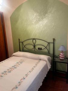 Un dormitorio con una cama y una pared verde. en Cortijo Algüit, en Vélez Blanco