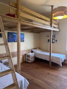 a bedroom with two bunk beds and a ladder at Humus Sapiens 2 in Tavarone
