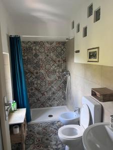 a bathroom with a shower and a toilet and a sink at Humus Sapiens 2 in Tavarone
