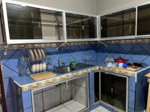 a kitchen with a sink and a blue tiled wall at Espacio Zeus in Comayagua