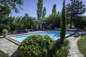 a swimming pool in a garden with trees at Le Ventoux in Tulette