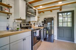 una cocina con armarios blancos y una puerta azul en Cozy Couples Retreat with Porch on Bayou Teche!, en New Iberia