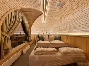 a bedroom with a large bed with a large window at Feinzeit Naturchalet mit Klima und Sauna in Frensdorf