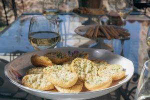 a white bowl of bread with a glass of wine at Campagne Médicis Piscine, jacuzzi & sauna privés in Juré
