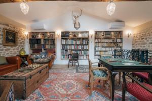 a living room filled with furniture and bookshelves at Campagne Médicis Piscine, jacuzzi & sauna privés in Juré