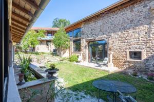 an external view of a stone house with a garden at Campagne Médicis Piscine, jacuzzi & sauna privés in Juré