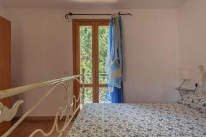 Un dormitorio con una cama y una puerta corrediza de vidrio. en Stunning Residence Bouganvillage 2 Bed Apt sleep 6, en Tanaunella