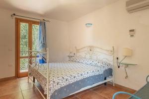 Un dormitorio con una cama y una puerta de cristal. en Stunning Residence Bouganvillage 2 Bed Apt sleep 6, en Tanaunella