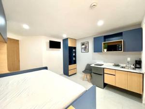 a bedroom with a bed and a kitchen with a sink at Living Alameda in Querétaro