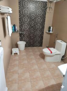 ein Badezimmer mit Toilette und Duschvorhang in der Unterkunft Coffee cottage guest house in Madikeri