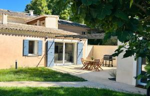 a patio with a table and chairs in front of a house at Le Jas de la Cascade in Les Vignères