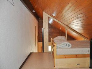 a bed in a room with a wooden ceiling at Charmant appartement familial avec mezzanine et balcon en centre-ville - FR-1-692-4 in La Chapelle-dʼAbondance