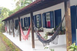 a building with hammocks in front of it at Pousada do Campo in Ipiabas