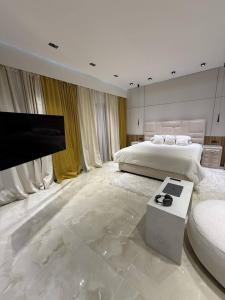 Un dormitorio blanco con una cama y un televisor. en Khatai Vip Apartment 2 bedrooms, en Baku