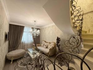 Una sala de estar con una lámpara de araña y una escalera de caracol. en Khatai Vip Apartment 2 bedrooms, en Baku