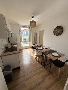 a dining room with four tables and a kitchen at Sweethome Massena in Nice