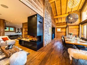 ein Wohnzimmer mit Kamin und Tisch in der Unterkunft Chalet Nyumbani : luxe et confort, skis aux pieds, proche lac et pistes, sauna, jacuzzi, solarium - FR-1-598-66 in Les Gets + 9 Fotos