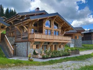 ein großes Holzhaus mit einem Gamer-Dach in der Unterkunft Chalet Nyumbani : luxe et confort, skis aux pieds, proche lac et pistes, sauna, jacuzzi, solarium - FR-1-598-66 in Les Gets