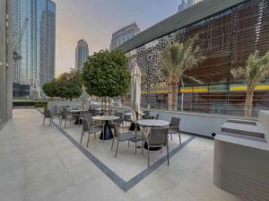 a patio with tables and chairs and buildings at Luxury 2BR Sea Burj views Khalifa infinity pool in Dubai