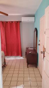 a bathroom with a red curtain and a mirror at Seaview Luxury Retreats in Montego Bay