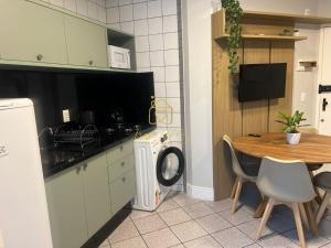a kitchen with a table and a washing machine at BETARA in Florianópolis