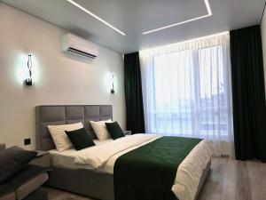a bedroom with a large bed and a window at Belvedere Apart 2, parking in Ivano-Frankivsʼk