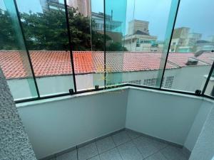 a room with large windows and a balcony with a view at BETARA in Florianópolis