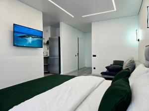 a bedroom with a large bed with a television on the wall at Belvedere Apart 2, parking in Ivano-Frankivsʼk