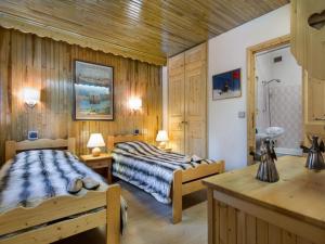 two beds in a room with wooden walls at Grand appart familial 3 pièces près centre et pistes avec wifi - FR-1-575-161 in Courchevel