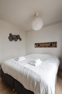 Una cama blanca con dos toallas en una habitación en Let's Go Nieuwpoort, en Nieuwpoort