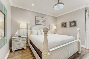 biała sypialnia z białym łóżkiem i szafką nocną w obiekcie High Pointe 433 w mieście Seacrest +40 zdjęć