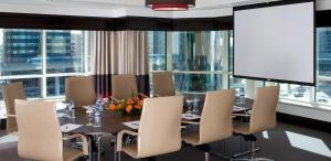 a dining room with a table and chairs and a large window at Towers Rotana - Dubai in Dubai +108 photos