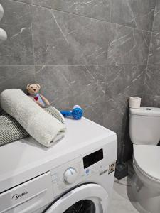 a teddy bear sitting on top of a washing machine at Новинка ЖК Тріумф поряд вокзалу in Luts'k