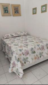 Bett mit Blumendecke in einem Schlafzimmer in der Unterkunft Andar Alto Frente Ipanema in Rio de Janeiro