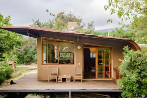 a small house with a porch and a deck at Cabañas de la Insolente in Tepoztlán +78 photos
