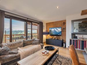 a living room with a couch and a table at Appartement avec Sauna et Jacuzzi aux Saisies - FR-1-809-14 in Les Saisies